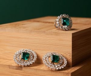 Emerald ring and pair of diamond earrings in gold, wedding jewelry with luxury gift box , close-up. Selective focus